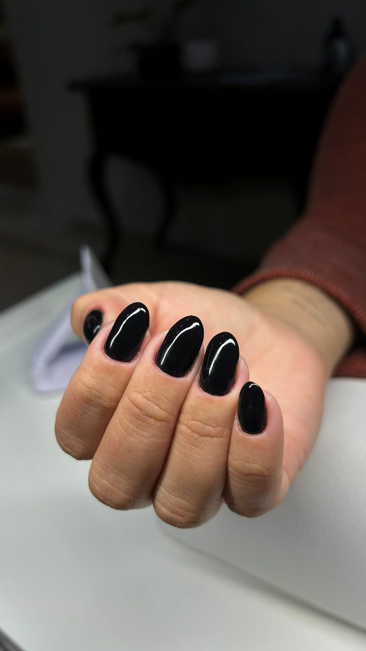 Banho de gel preto em unhas ovais